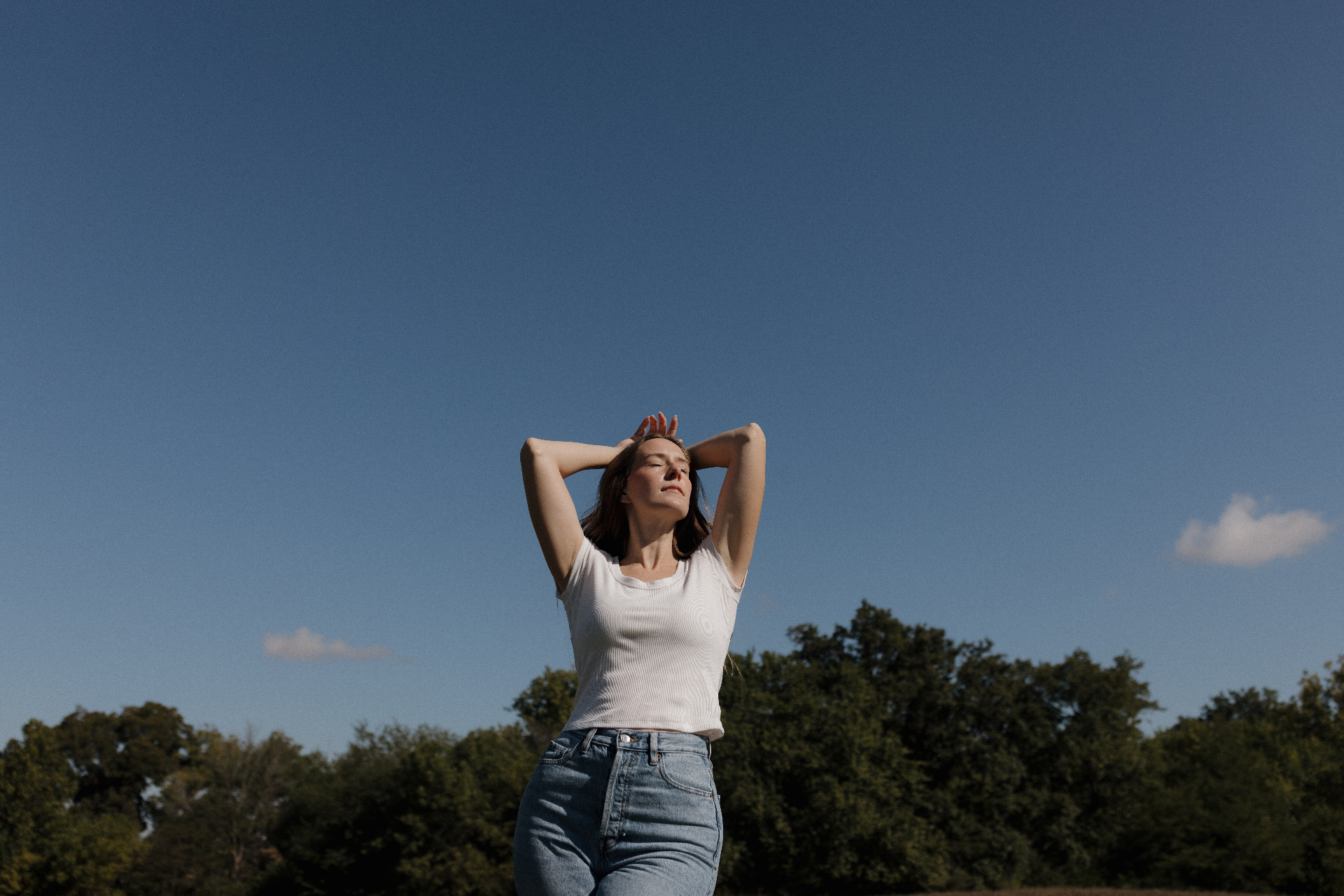 Ariel standing in a field under an open blue sky