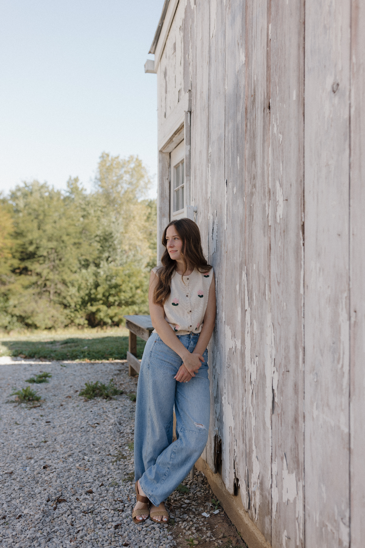 Ariel leaning against a weathered farm building